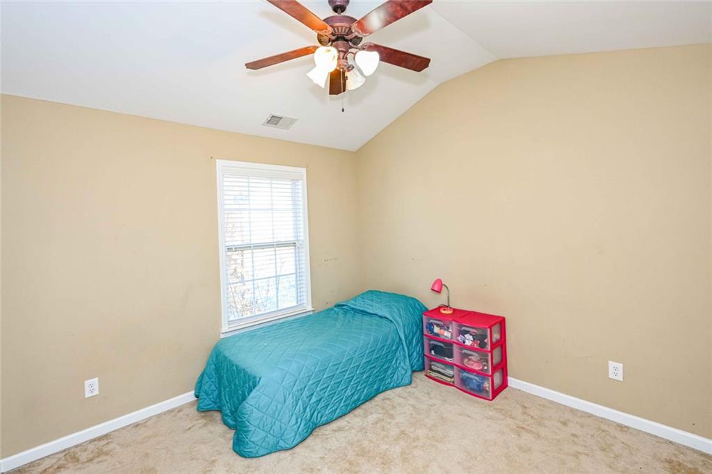 1024 Landon Drive Villa Rica, GA 30180 - Photo 37 of 50 a bedroom with a bed and a chandelier fan