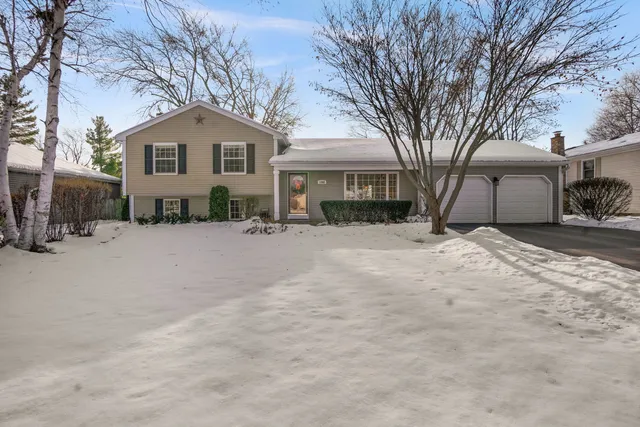 a view of a house with a yard covered in snow