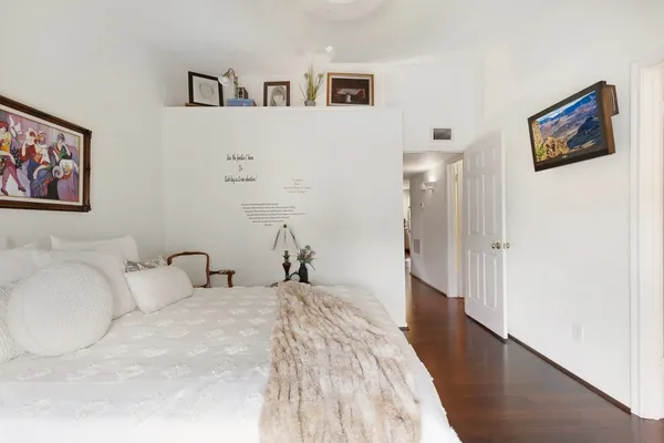 a bedroom with a bed and a painting on the wall