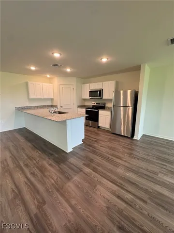 a kitchen with stainless steel appliances granite countertop a refrigerator sink and cabinets