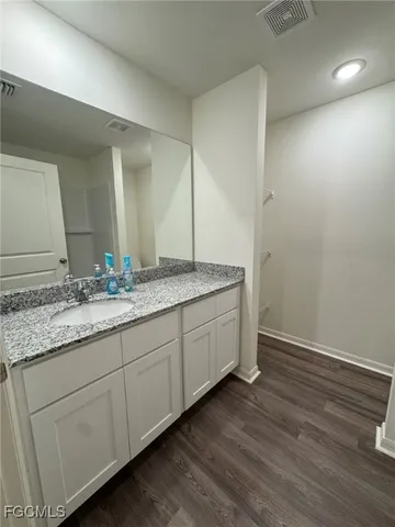 a bathroom with a granite countertop sink and a mirror