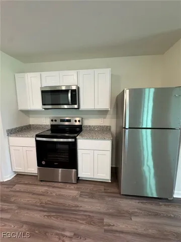 a kitchen with a refrigerator and a stove top oven