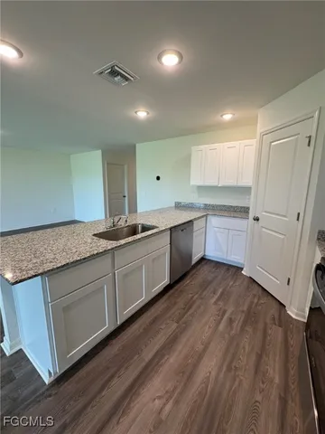 a kitchen with sink cabinets and wooden floor