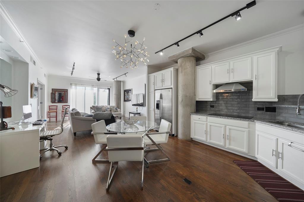 a living room with stainless steel appliances kitchen island granite countertop furniture a rug and white walls