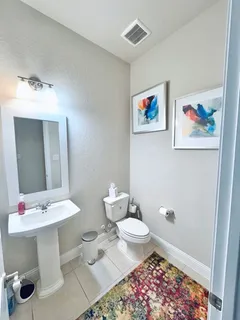 a bathroom with a sink mirror and toilet
