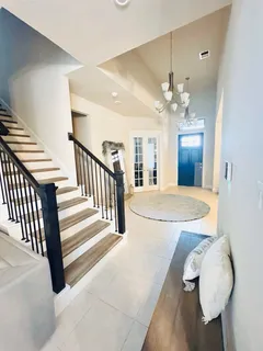 a view of a livingroom with a fireplace a chandelier fan and wooden floor