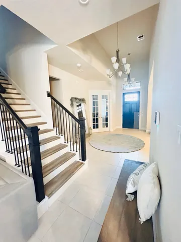 a view of a livingroom with a fireplace a chandelier fan and wooden floor