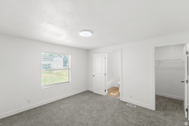 2600 North Hill Field Road, Unit 103A Layton, UT 84041 - Photo 12 of 31 Spacious room featuring neutral carpeting, white walls, a double-hung window, a flush-mount ceiling light, and access to a closet with wire shelving