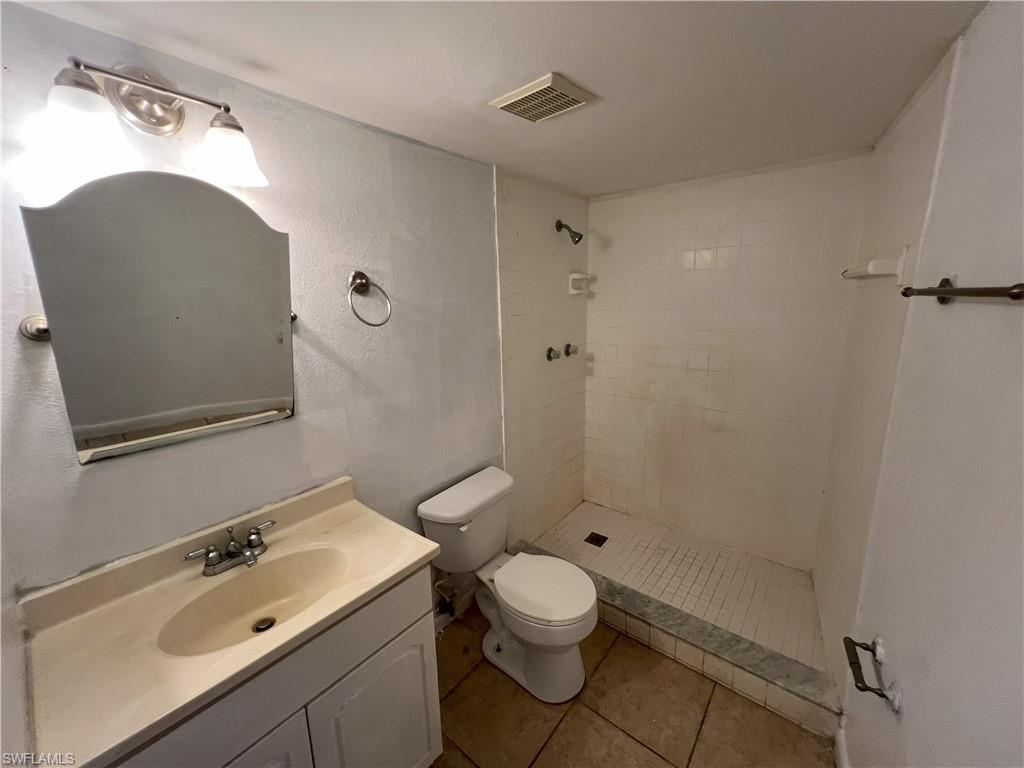 4290 Gulfstream Drive, Unit 16 Naples, FL 34112 - Photo 11 of 11 a bathroom with a sink mirror vanity and toilet