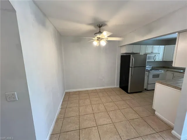 an empty room with a stove and a refrigerator