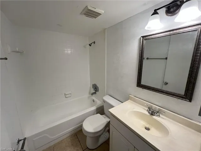 a bathroom with a sink mirror toilet and bathtub