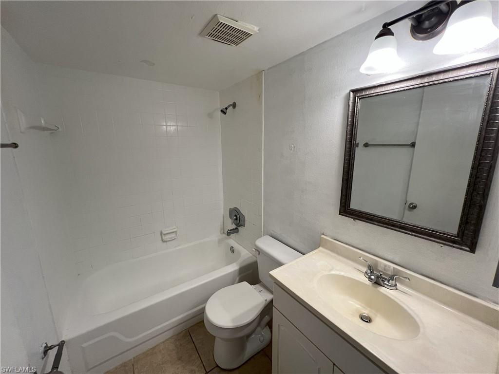 4290 Gulfstream Drive, Unit 16 Naples, FL 34112 - Photo 8 of 11 a bathroom with a sink mirror toilet and bathtub