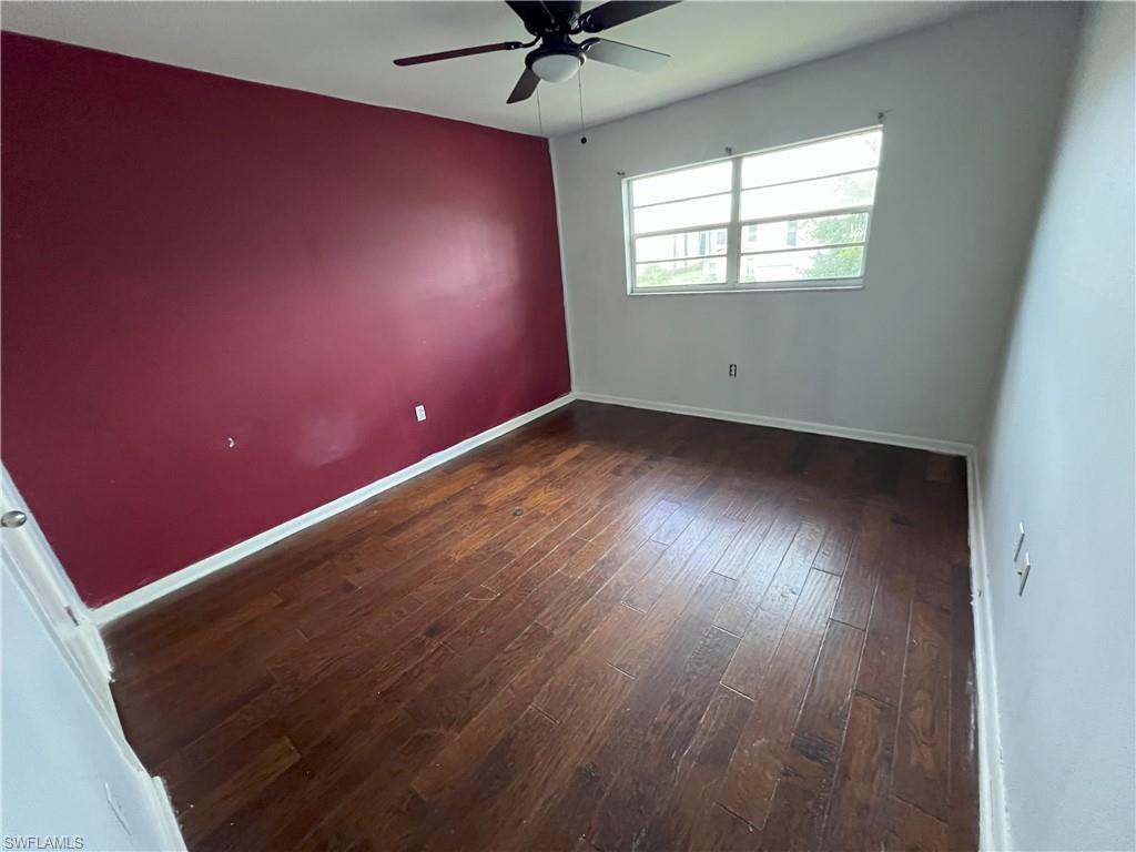 4290 Gulfstream Drive, Unit 16 Naples, FL 34112 - Photo 10 of 11 an empty room with wooden floor and windows