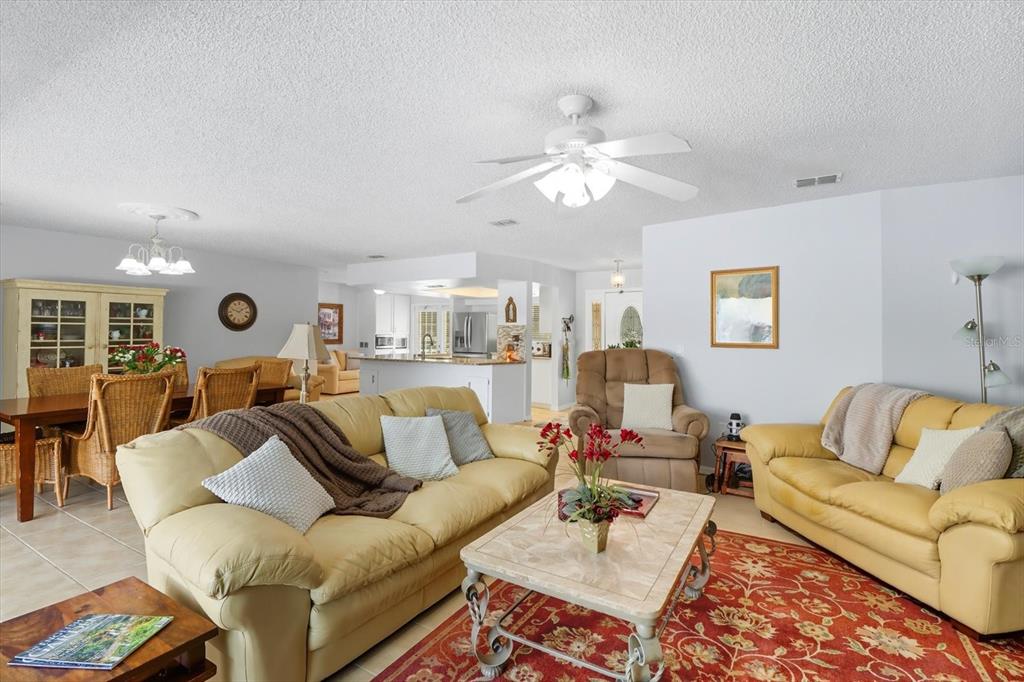 12550 Southwest 16th Avenue Ocala, FL 34476 - Photo 16 of 63 a living room with furniture kitchen view and a chandelier
