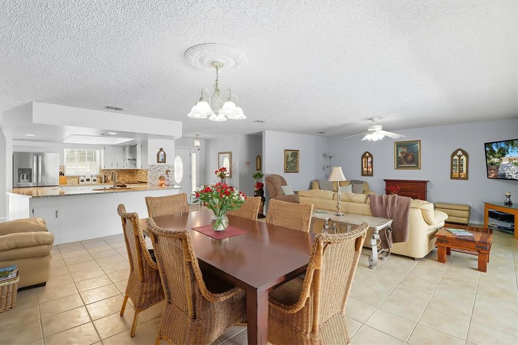 12550 Southwest 16th Avenue Ocala, FL 34476 - Photo 17 of 63 a view of a dining room and livingroom with furniture a rug a painting and a chandelier