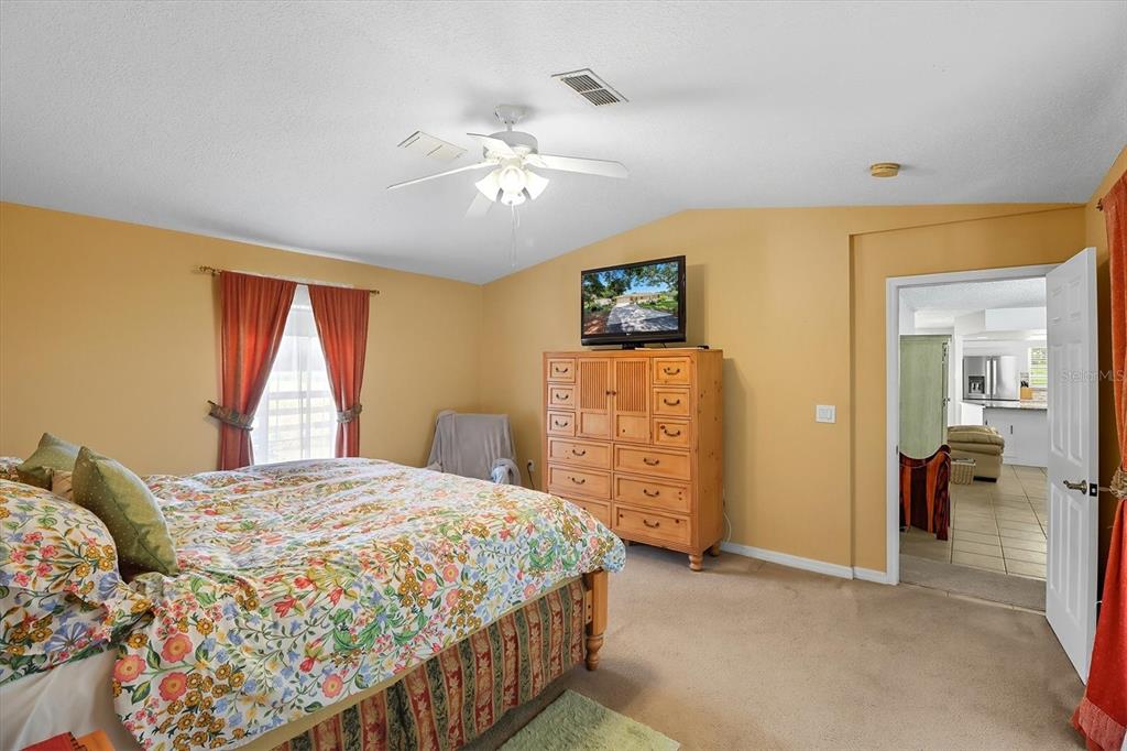 12550 Southwest 16th Avenue Ocala, FL 34476 - Photo 22 of 63 a bedroom with a bed and a chandelier