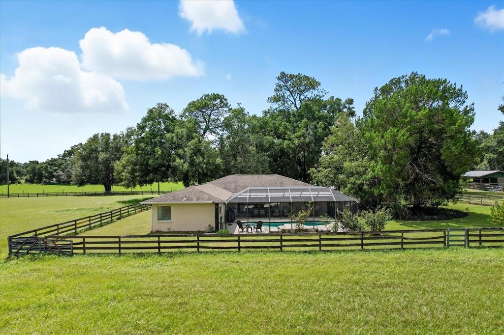 12550 Southwest 16th Avenue Ocala, FL 34476 - Photo 32 of 63 a view of a swimming pool with a table and chairs under an umbrella