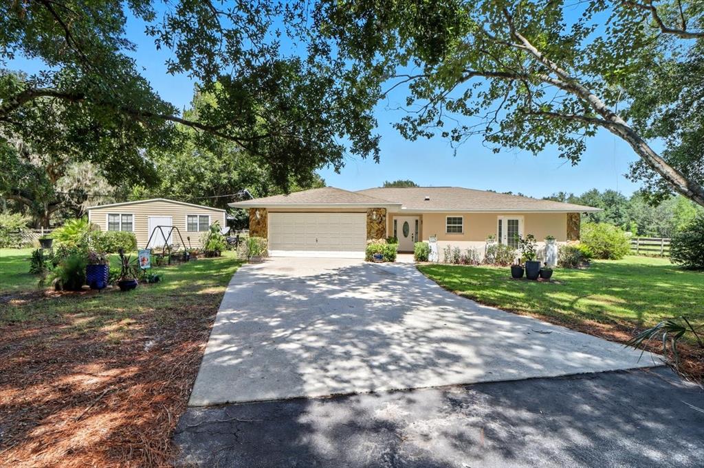 12550 Southwest 16th Avenue Ocala, FL 34476 - Photo 33 of 63 a front view of a house with a garden and yard