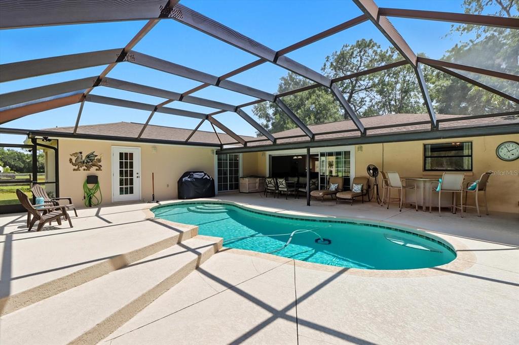 12550 Southwest 16th Avenue Ocala, FL 34476 - Photo 5 of 63 a view of a backyard with table and chairs under an umbrella
