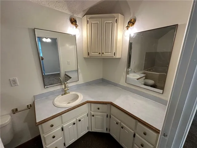 a bathroom with a toilet sink and mirror