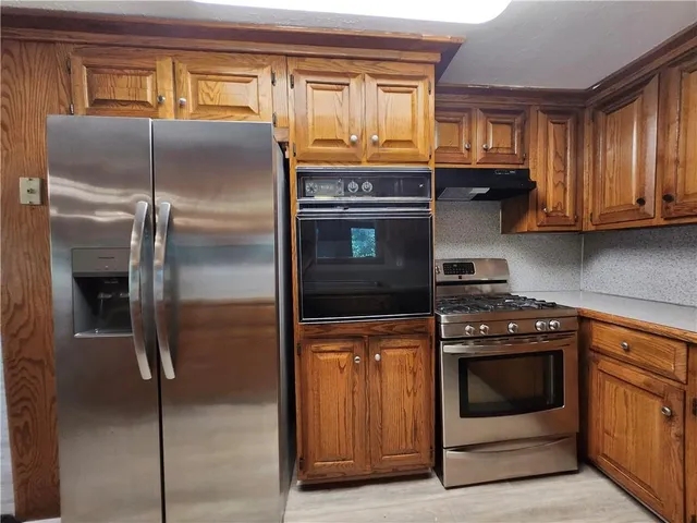 a kitchen with granite countertop a stove and a refrigerator