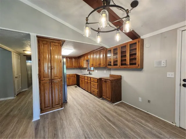 a large room with wooden floor and stainless steel appliances