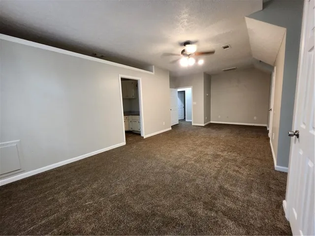 en empty room with windows and fan