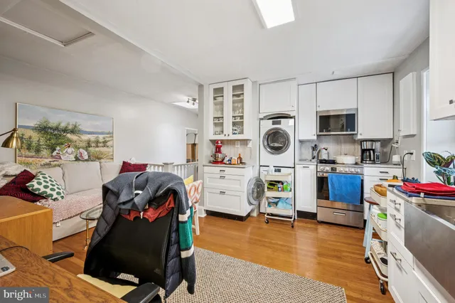 a view of a kitchen with wooden cabinets and washer dryer