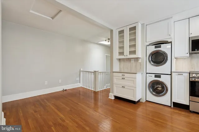 a kitchen with white cabinets and window