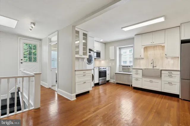 a living room with furniture kitchen view and large windows