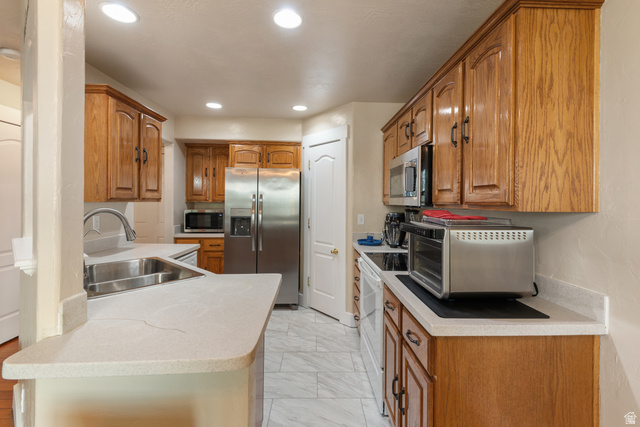 802 Brookside Court Payson, UT 84651 - Photo 14 of 32 Kitchen featuring wood finish cabinetry, light countertops, stainless steel appliances, a peninsula, and recessed lighting