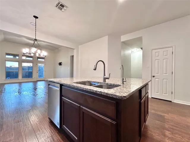 a kitchen with granite countertop cabinets stainless steel appliances and a sink