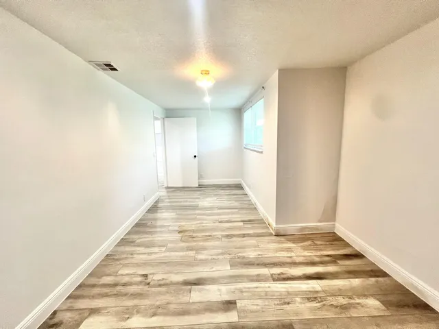 a view of a room with wooden floor and window