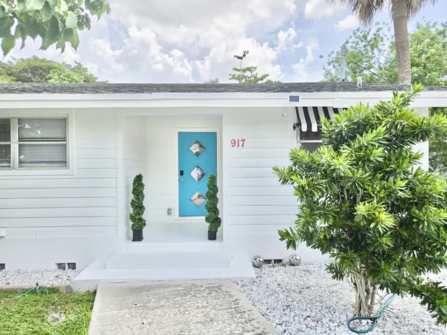 a front view of a house with plants