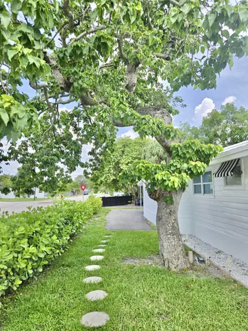 a view of a house with a patio and a yard