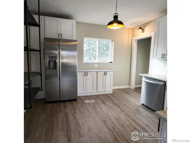 a kitchen with kitchen island wooden floor and refrigerator
