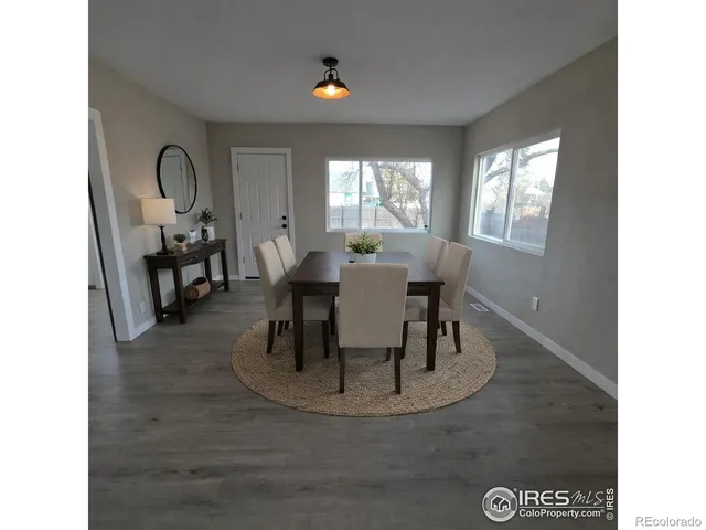 a dining room with wooden floor a glass table and chairs