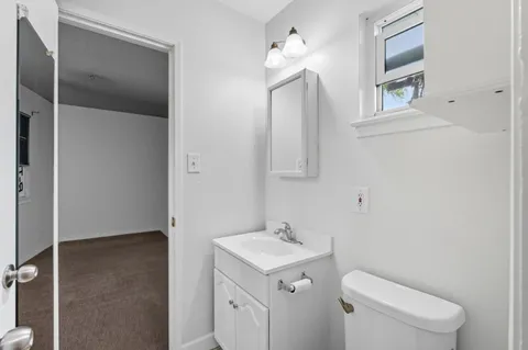 a bathroom with a toilet sink and mirror