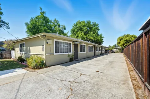 a front view of house with yard and trees around