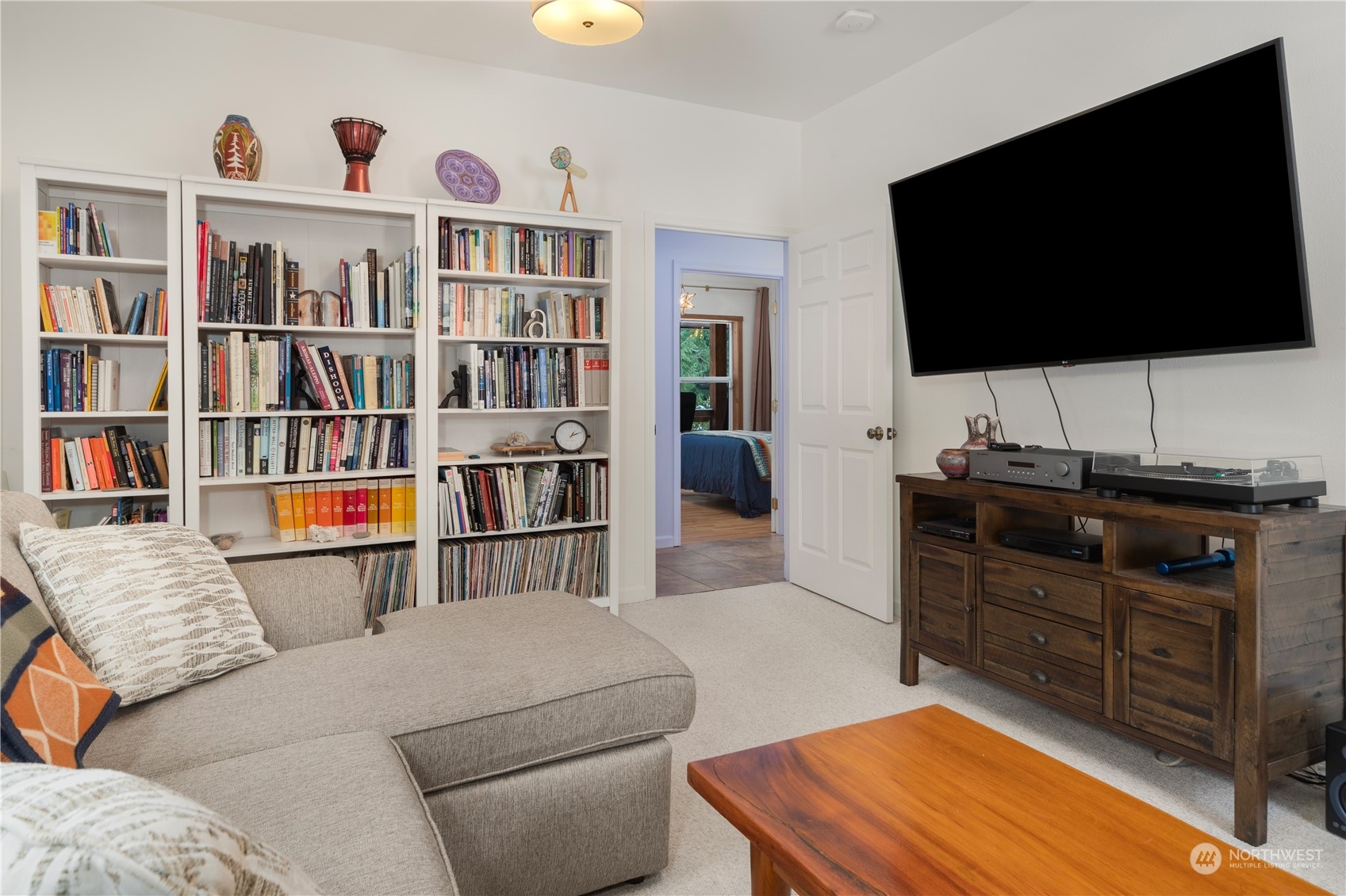 232 Peterson Road Port Townsend, WA 98368 - Photo 11 of 32 a living room with a flat screen tv and a book shelf