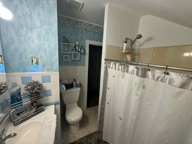 a bathroom with a toilet and a shower curtain