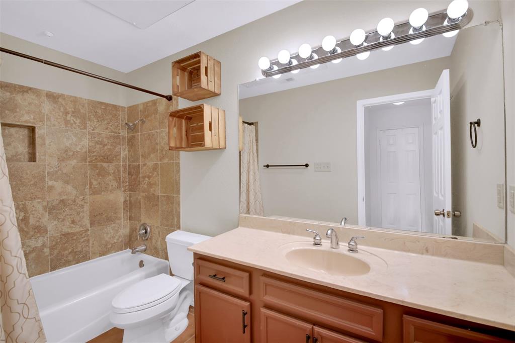 9100 Mountain Ridge Drive, Unit 102 Austin, TX 78759 - Photo 15 of 24 Bathroom with vanity and shower / bath combination with curtain