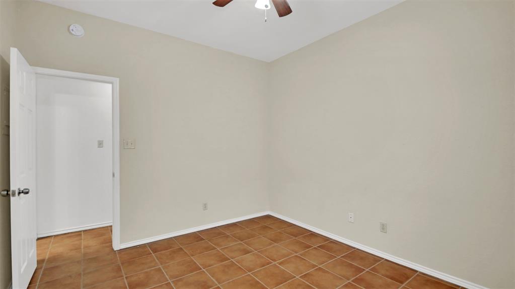 9100 Mountain Ridge Drive, Unit 102 Austin, TX 78759 - Photo 17 of 24 Unfurnished room featuring baseboards and a ceiling fan