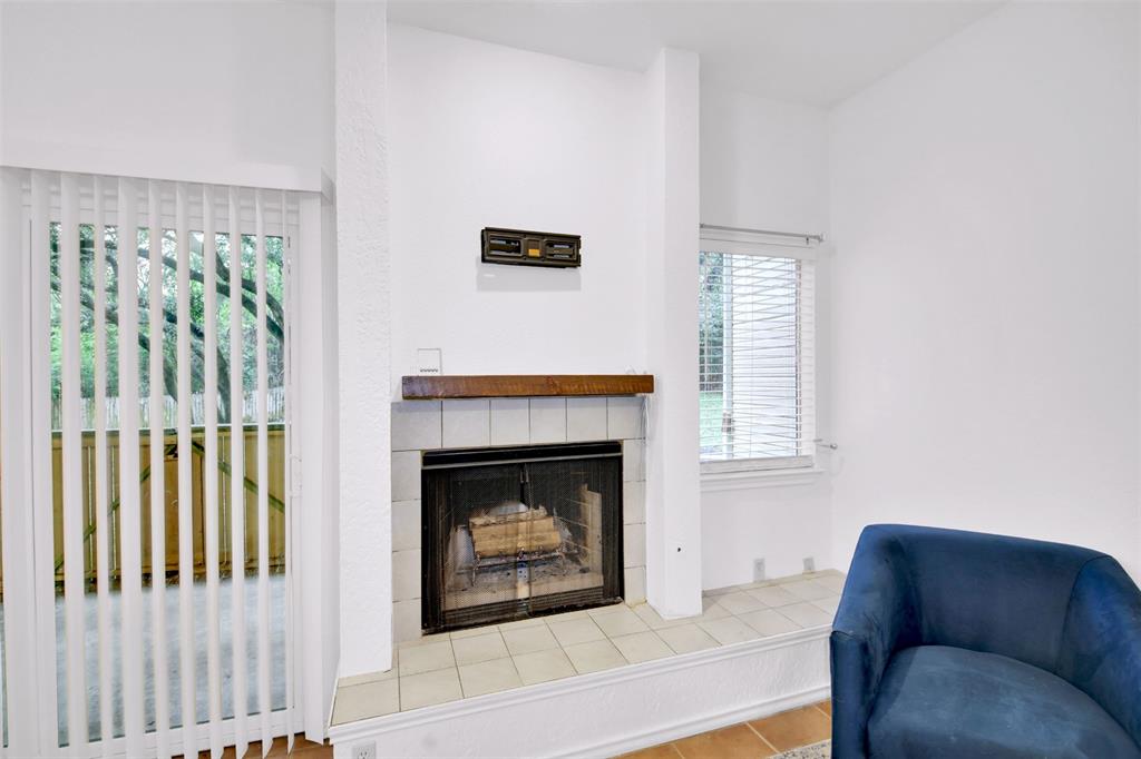9100 Mountain Ridge Drive, Unit 102 Austin, TX 78759 - Photo 7 of 24 Living area with a tiled fireplace and light wood-style flooring
