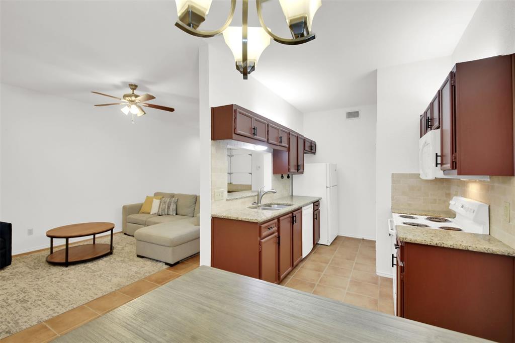 9100 Mountain Ridge Drive, Unit 102 Austin, TX 78759 - Photo 24 of 24 Kitchen featuring white appliances, a chandelier, backsplash, ceiling fan, and open floor plan