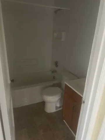 a white toilet sitting next to a shower