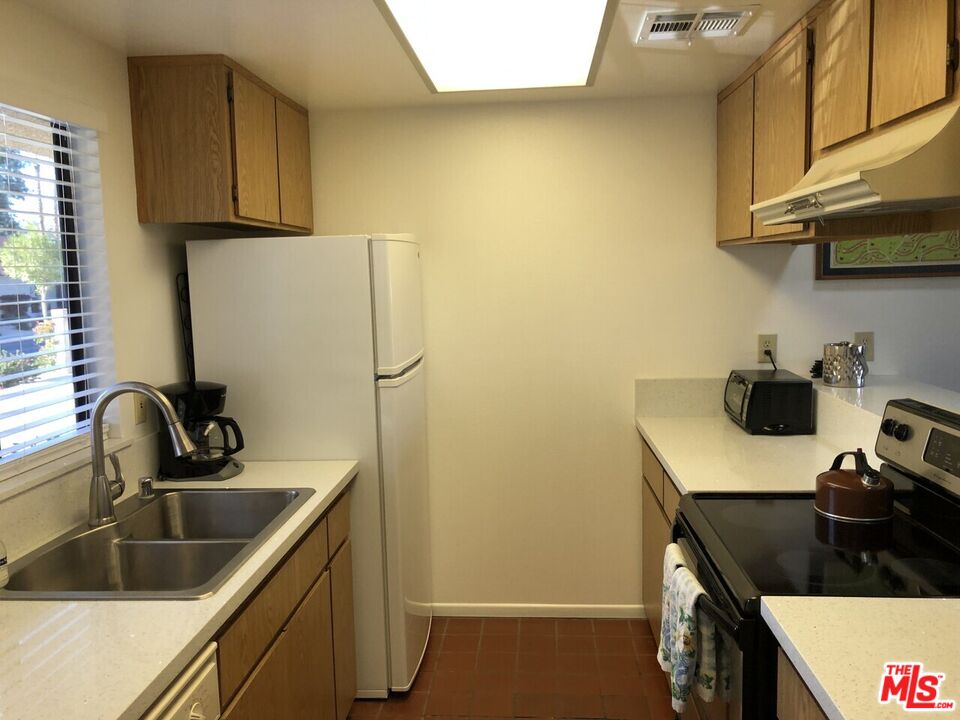 40590 La Costa Circle East, Unit 7303 Palm Desert, CA 92211 - Photo 3 of 14 a kitchen with a sink a stove and cabinets