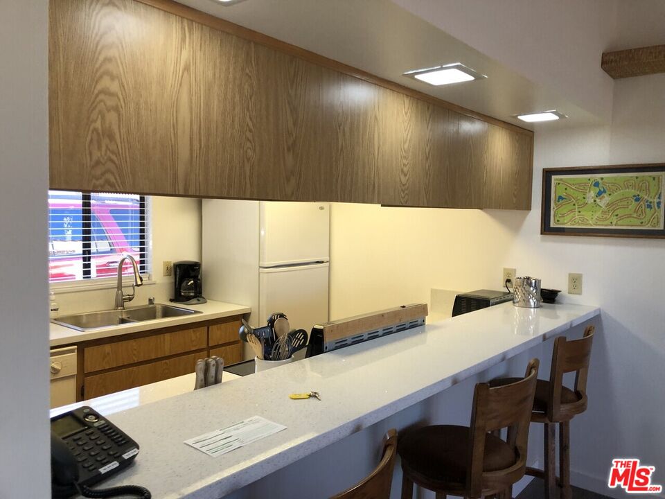 40590 La Costa Circle East, Unit 7303 Palm Desert, CA 92211 - Photo 4 of 14 a kitchen with a sink and a refrigerator