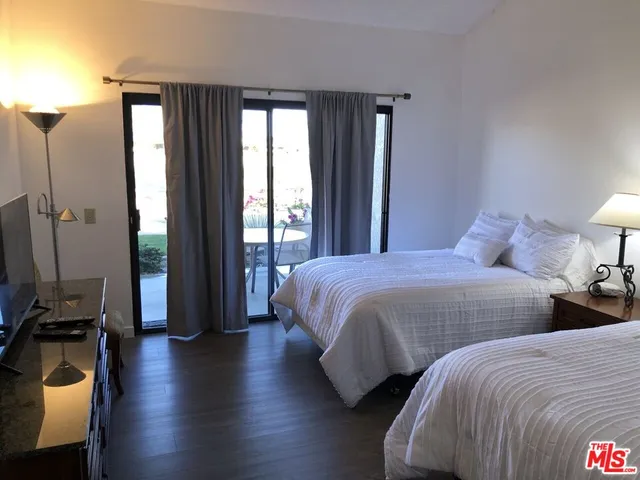 a bedroom with two beds and large window