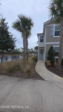 a view of a house with a yard and palm trees